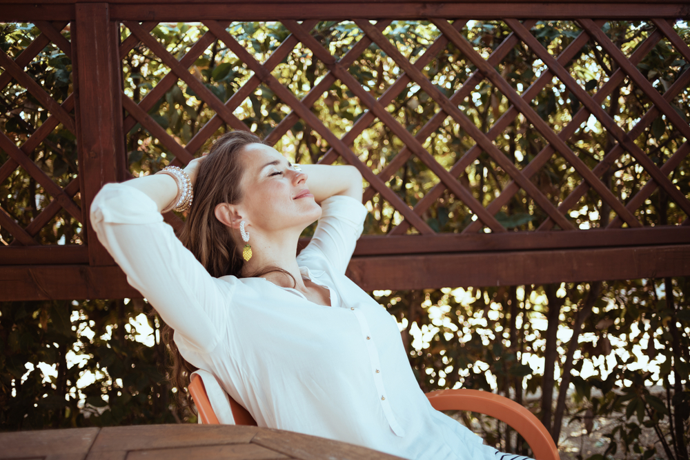 Benefits of Pergolas, Verandahs, and Patios; Extra relaxation and recreational space:

relaxed, young, housewife, in, white, shirt, sitting, at, the, table