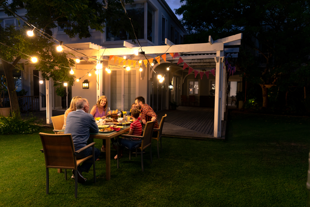 The Benefits of Adding a Pergola to Your Outdoor Space, Offers shaded space for leisure and social events:
side, view, of, a, multi generation, caucasian, family, sitting, in, the